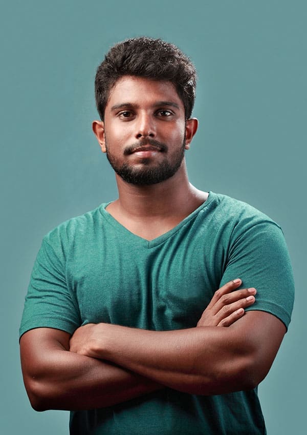 Portrait of a young man of indian origin against a blue background